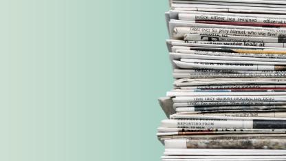 Zeitungsstapel vor grünem Hintergrund