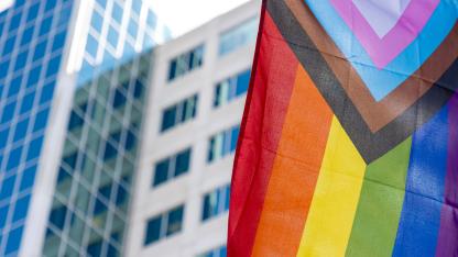 Hochhaus mit Progressive Pride Flagge