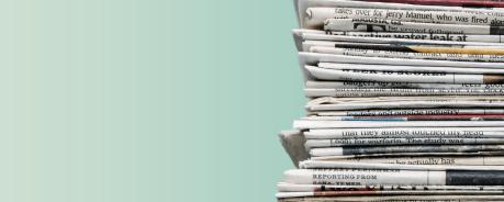 Zeitungsstapel vor grünem Hintergrund