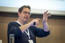 Dr. Markus Bickel Person vor Mikrofon gestikulierend