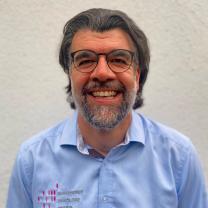 PD Dr. R. Vogelmann Männlich gelesene Person mit Bart und Brille lächelt in die Kamera