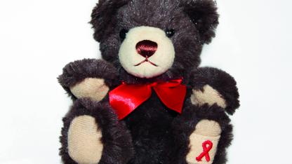 Dunkelbrauner Teddybär mit roter Schleife